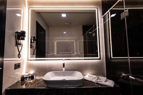 a bathroom with a sink and a large mirror at The Fifth Floor by Old Town Hotel in Timişoara