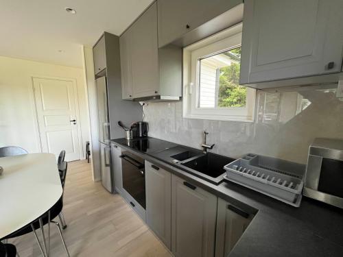 a kitchen with a sink and a window at Modern Lakeside Hideaway in Örebro