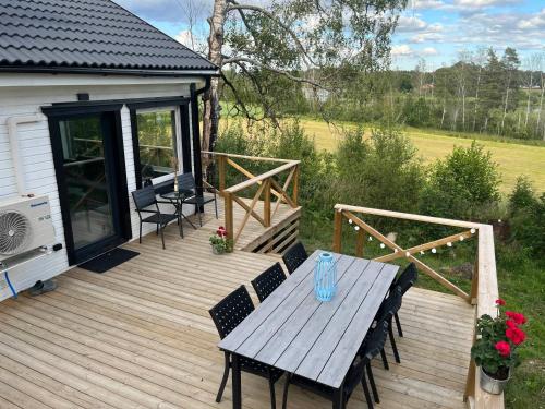 a wooden deck with a table and chairs on it at Modern Lakeside Hideaway in Örebro