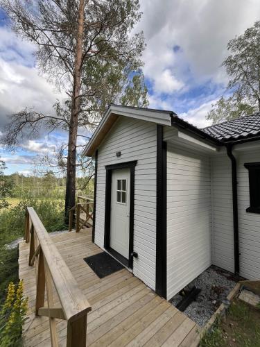 a small white building with a wooden deck at Modern Lakeside Hideaway in Örebro