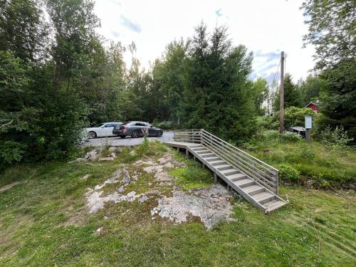 a wooden bridge over a field with a car at Modern Lakeside Hideaway in Örebro