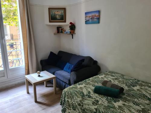a living room with a couch and a table at Appartement calme in Clichy