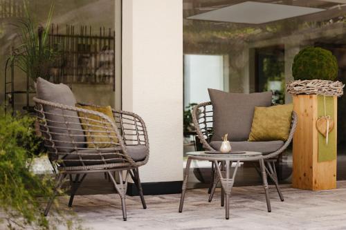 two chairs and a table on a patio at Untermairhof Appartment Residence in Selva dei Molini