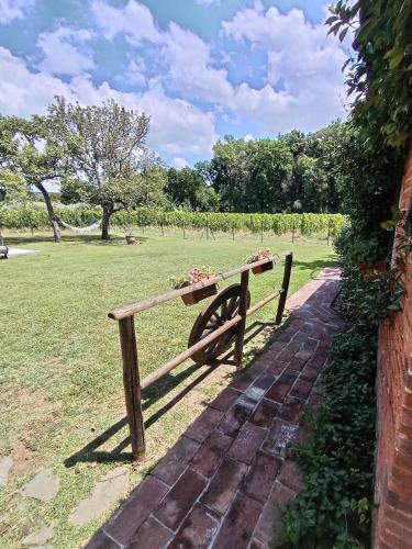 a wooden bench sitting on a brick path in a field at Casale - La Camera di Leda in Lamporecchio