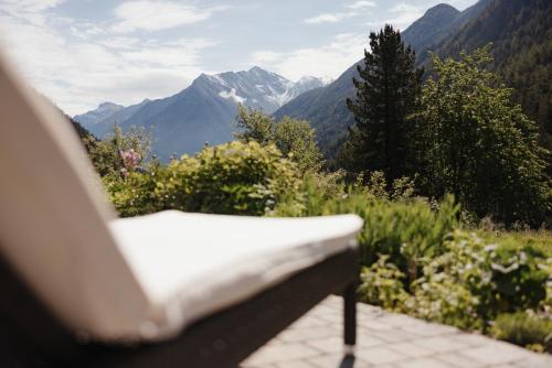 a bench sitting on a patio with a view of mountains at Untermairhof Appartment Residence in Selva dei Molini