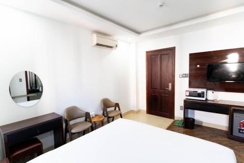 a room with a bed and a tv and a desk at Mama Hotel And Apartment - Free Sauna And Gym in Da Nang