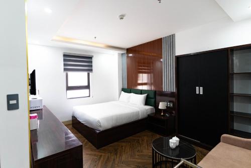 a hotel room with a bed and a couch at Mama Hotel And Apartment - Free Sauna And Gym in Da Nang