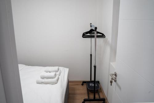 a room with a bed with white sheets and towels at Apartmani Novakovic in Velika Plana