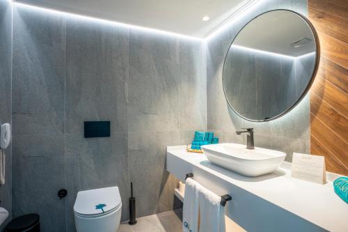 a bathroom with a sink and a mirror at Qlusive Hotel in Kusadası