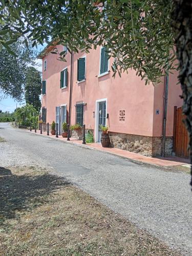 a pink building on the side of a road at Casale - La Camera di Leda in Lamporecchio