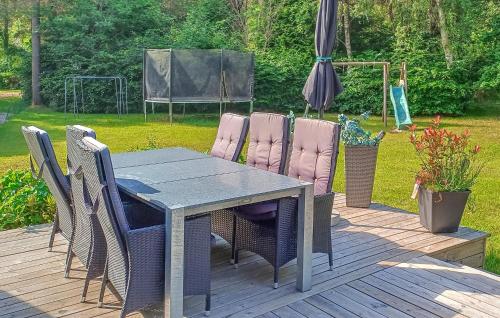 una mesa y sillas en una terraza con sombrilla en Nice Home In Hadsund With 2 Bedrooms, en Hadsund
