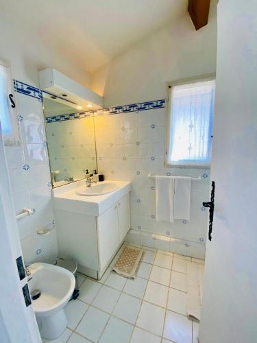 une salle de bain blanche avec un lavabo et des toilettes dans l'établissement Panoramic Sea View Villa in private residence with pool, à Théoule-sur-Mer