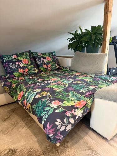 a bed in a room with a floral blanket at 120m2 APARTAMENT LAS I JEZIORO in Człuchów