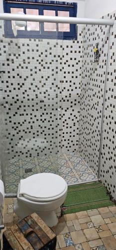 a bathroom with a white toilet in a shower at Chalé Pocinho in Tiradentes