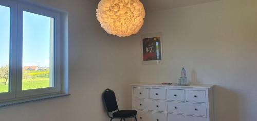 a room with a dresser and a window and a chair at JM Swiss Space in Langrickenbach