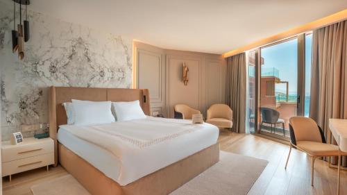 a bedroom with a large bed and a balcony at Qlusive Hotel in Kusadası