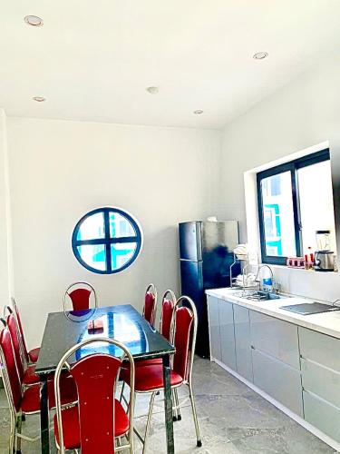 a dining room with a table and red chairs in a kitchen at Anna Belle Đồi Rồng Hotel - Homestay chuỗi HPT Home Hải Phòng in Kon Rung (1)