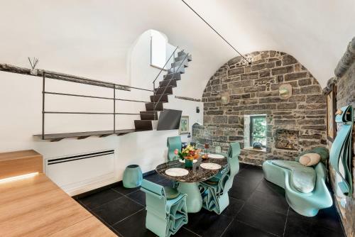 a room with a table and chairs and a brick wall at Capitolare Suite Tower in Portovenere