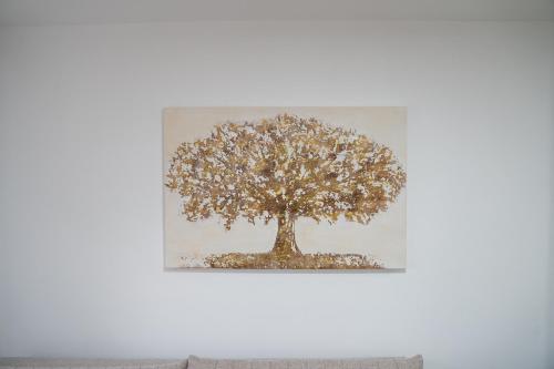 a picture of a tree on a white wall at Apartmani Novakovic in Velika Plana