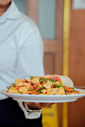 a person is holding a plate of food at 泊悦国际大酒店 BoYue Hotel in Addis Ababa Bole International Airport