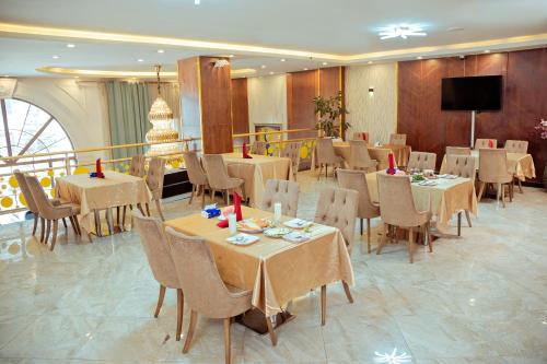a dining room with tables and chairs and a television at 泊悦国际大酒店 BoYue Hotel in Addis Ababa Bole International Airport