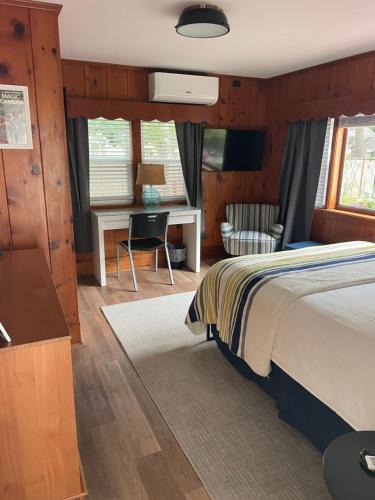 ein Schlafzimmer mit einem Bett und einem Schreibtisch in einem Zimmer in der Unterkunft Cape Cod Motor Inn in South Yarmouth