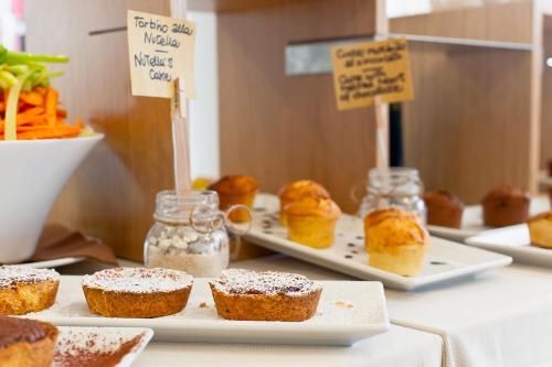 a table with muffins and other pastries on at Hotel Stella Della Versilia in Marina di Massa