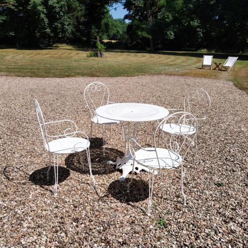 a table and two chairs and a table and a table and chairs at Le manoir d'Estiveaux in Le Châtelet