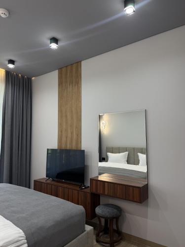 a bedroom with a bed and a flat screen tv at BOND HOUSE Dilijan in Dilijan