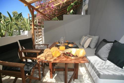 a table with a bowl of bread and fruit on a balcony at Axilleion Boutique Hotel in Ermoupoli