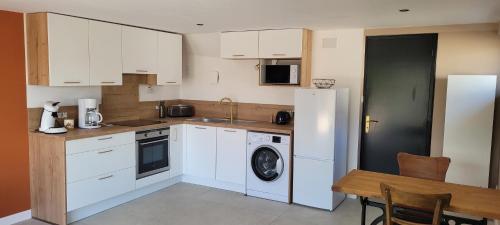 a kitchen with white cabinets and a washer and dryer at 2 Gites dans les remparts à Dun sur Meuse in Dun-sur-Meuse