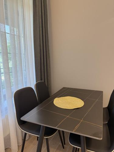 a dining room table with black chairs and a yellow rug on it at BOND HOUSE Dilijan in Dilijan