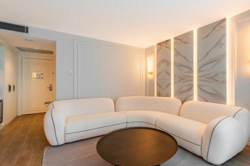 a living room with a white couch and a coffee table at Qlusive Hotel in Kusadası