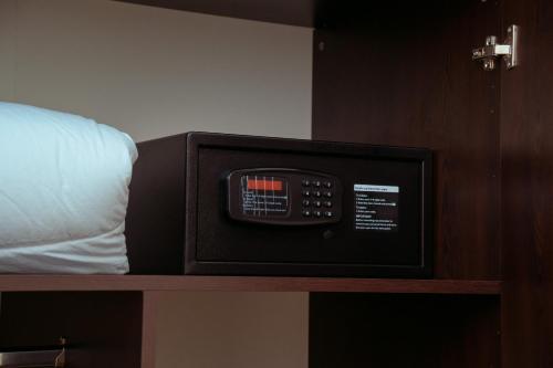 a microwave oven sitting on a shelf next to a bed at 泊悦国际大酒店 BoYue Hotel in Addis Ababa Bole International Airport