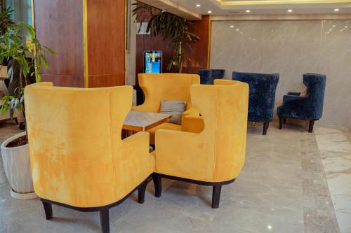 a group of yellow chairs and a table in a lobby at 泊悦国际大酒店 BoYue Hotel in Addis Ababa Bole International Airport