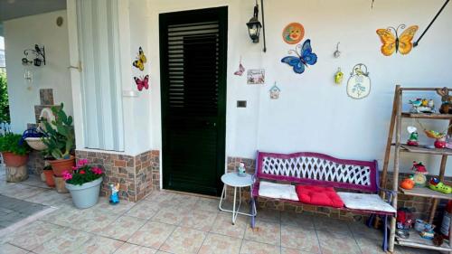 a porch with a bench and butterflies on the wall at DIMORA MELISSA in Colà di Lazise