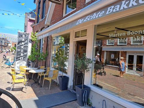 a store with tables and chairs outside of a building at Fries Vakantiehuis, grote tuin, nabij het Pikmeer in Grou