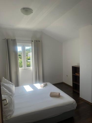 a white bed in a room with a window at Apartment Andrea in Orebić