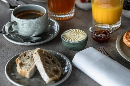 a table with a plate of bread and a cup of coffee at Thalazur Carnac in Carnac