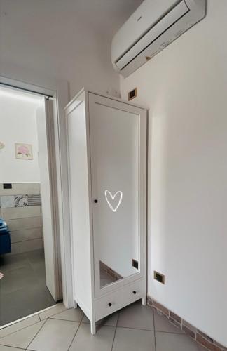 a white cabinet with a heart on it in a room at DIMORA MELISSA in Colà di Lazise