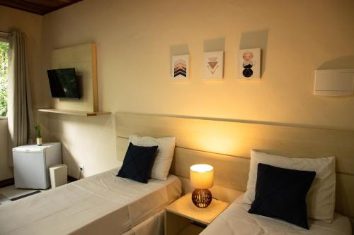 a hotel room with two beds and a lamp at Lonier Nature INN in Abraão