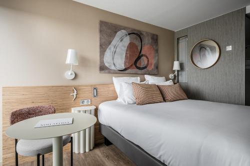 a hotel room with a bed and a table at Thalazur Carnac in Carnac