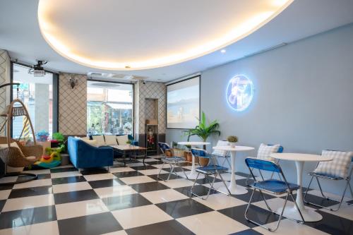 a lobby with chairs and tables and windows at 日日藍旅市區民宿 in Hualien City