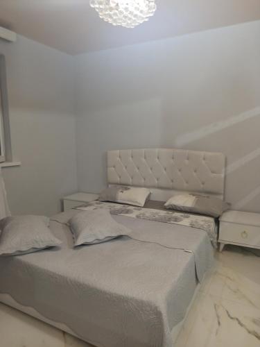 a bedroom with a large bed with a white wall at Belas House With Terrace in Kutaisi