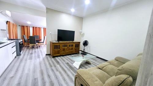 a living room with a couch and a flat screen tv at The Blue Donkey in Paramaribo
