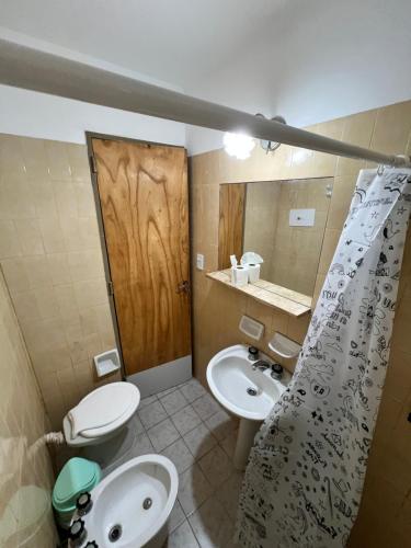 une salle de bain avec deux lavabos et un WC et un miroir dans l'établissement Nuevo Hotel Córdoba, à Villa Carlos Paz
