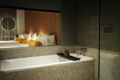 a bathroom with a sink and a mirror at Graph Hotels Bangkok in Bangkok