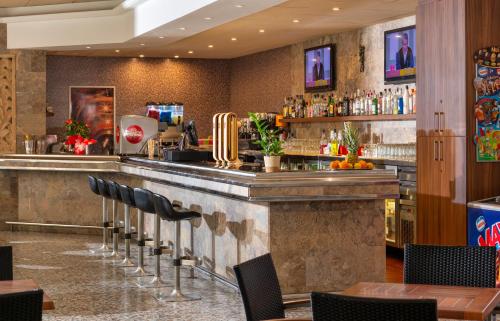 a bar in a restaurant with black chairs at Hotel la Palmera & Spa in Lloret de Mar
