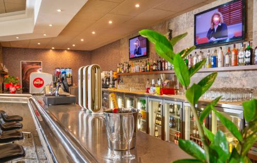 a bar with a counter with alcohol bottles at Hotel la Palmera & Spa in Lloret de Mar