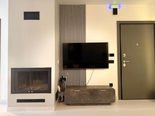 a living room with a flat screen tv and a entertainment center at Light & kozy apartment in Patra